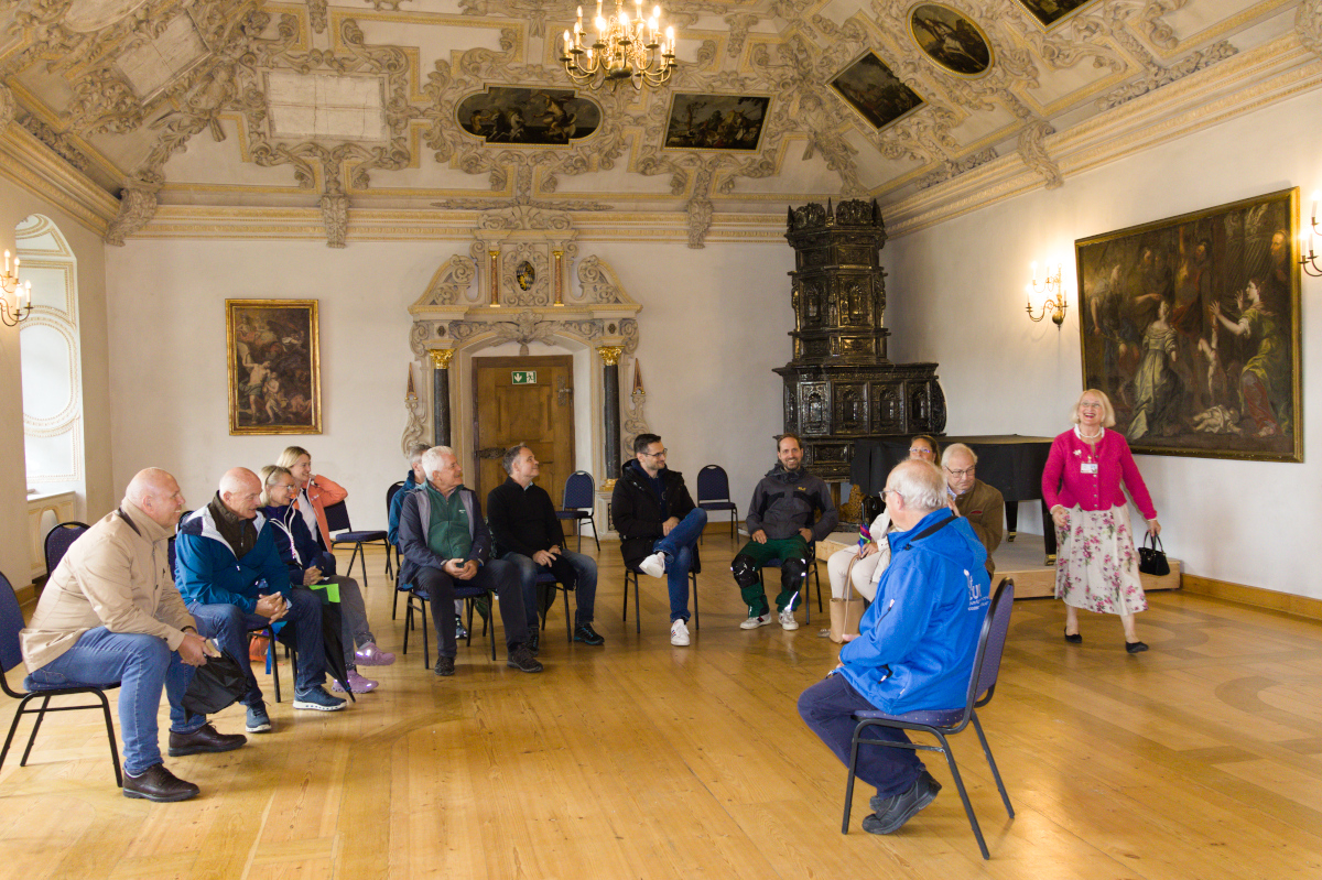 Pater Karl Geißinger (SDB) und die Besuchergruppe im historischen Barocksaal des Kloster Benediktbeuern.